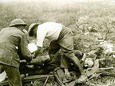 Canadians bringing in a wounded German soldier